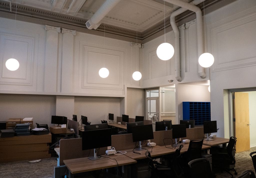 Original plaster panel walls with new globe pendant lighting over the workspace